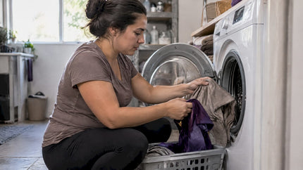 Cotton and polyester garments sorted beside washer
