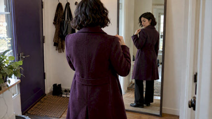 Woman checking coat shoulder and sleeve fit