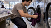 Plum polyester polo being loaded into washer