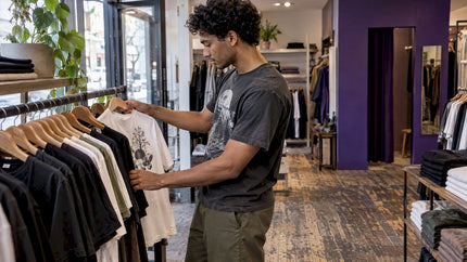 Shopper browsing graphic tees in a clothing store