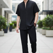 Person wearing a black outfit with a plain background
