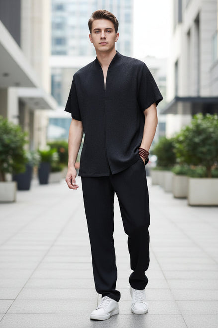 Person wearing a black outfit with a plain background