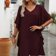 Woman wearing a burgundy dress with a neutral background