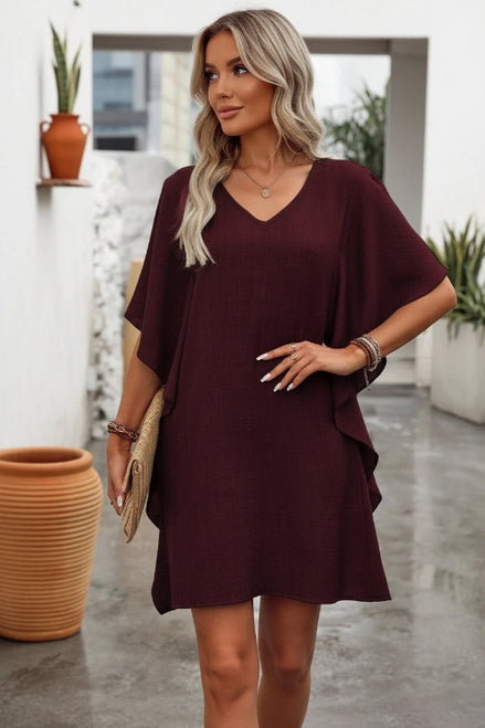 Woman wearing a burgundy dress with a neutral background