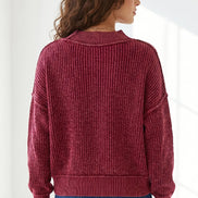 A woman viewed from the back wearing a ribbed knit sweater in a deep burgundy red, paired with blue jeans, against a bright white background.