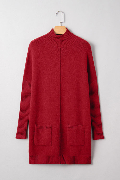 Red sweater dress on a hanger against a white background