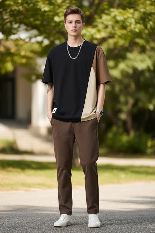 Person wearing a black and brown color-blocked t-shirt on a white background