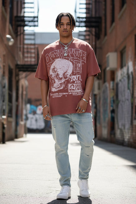 Person wearing a red graphic t-shirt with text and a skull design.