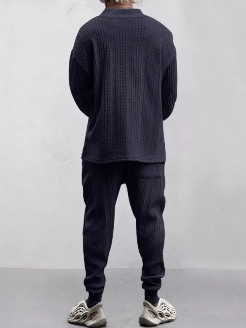 A person shown from the back wearing a dark navy cable-knit long-sleeve top and matching jogger pants, 