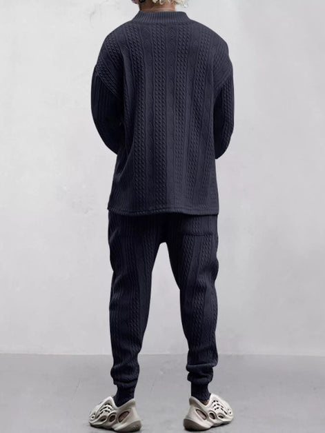 A person shown from the back wearing a dark navy cable-knit long-sleeve top and matching jogger pants, 