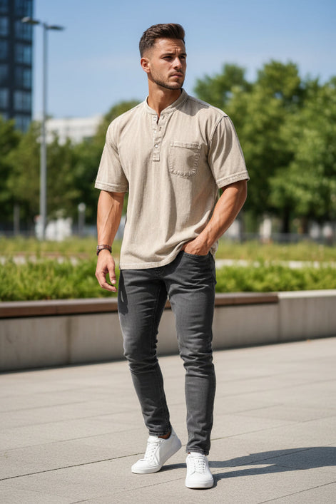 Man wearing a beige short-sleeve shirt with a pocket on a white background