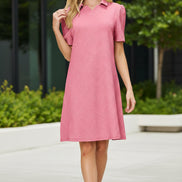 Woman wearing a pink dress with a collar on a beige background