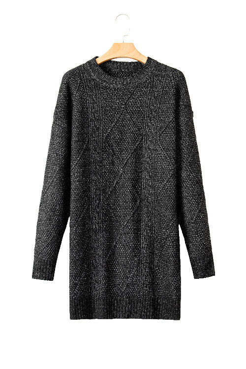 Black cable knit sweater dress on a wooden hanger against a white background