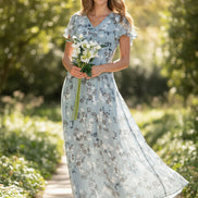 Woman wearing a light blue floral dress holding white flowers on a white background