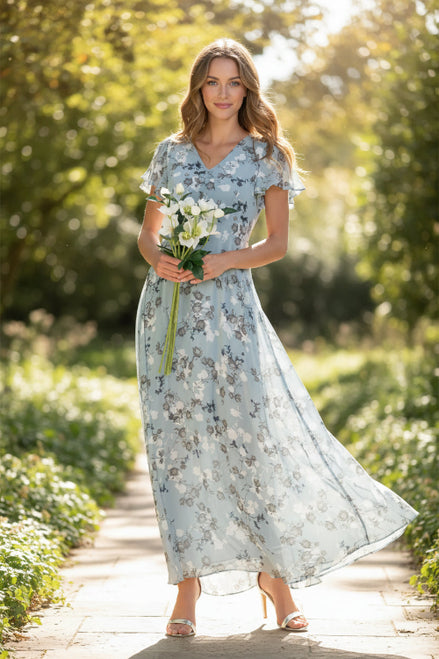 Woman wearing a light blue floral dress holding white flowers on a white background