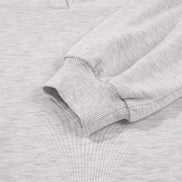 Close-up of a gray sweatshirt with a focus on the sleeve and collar.