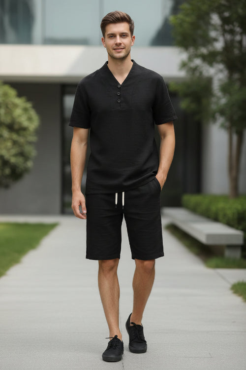 Black outfit with a shirt and pants on hangers against a white background