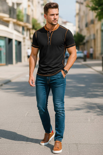 Man wearing a black short-sleeve shirt with brown accents, standing outdoors.