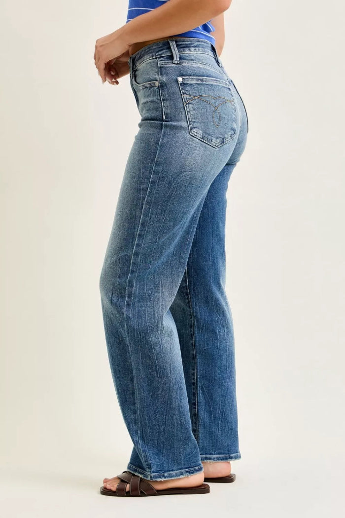 Person wearing light blue jeans on a plain background