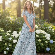 Woman wearing a light blue floral dress on a white background