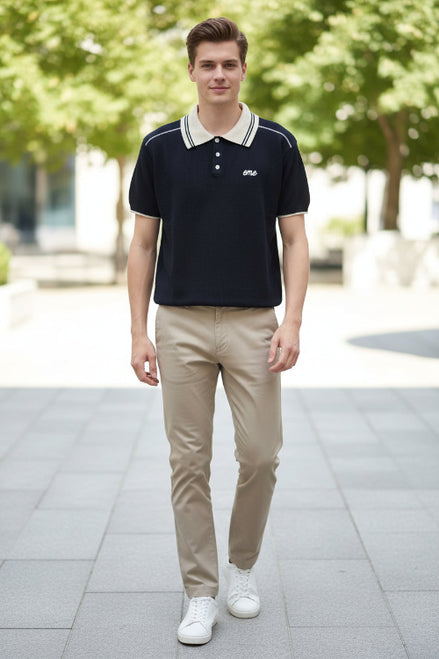 Person wearing a navy blue polo shirt with a white collar and 'eme' logo.