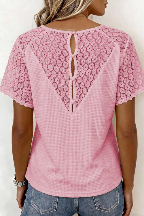 Pink lace top worn by a person on a white background