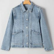 Light blue denim jacket with ruffled collar on a hanger against a white background