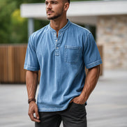 Man wearing a blue denim shirt with a pocket on a white background
