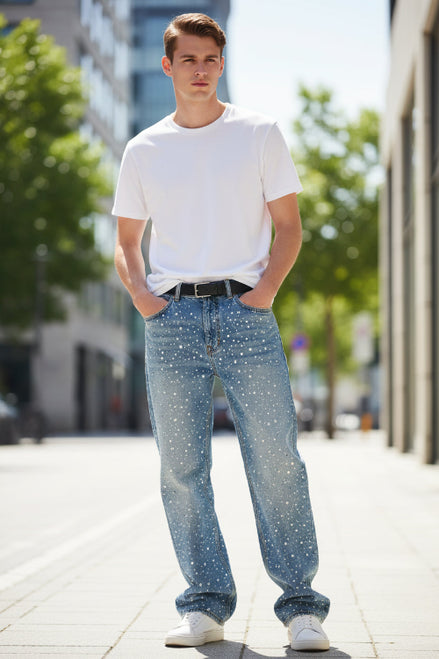 Person wearing a long coat, jeans, and a graphic t-shirt with a dark background