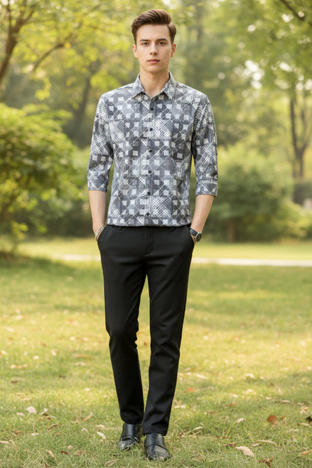Person wearing a patterned shirt with geometric design against a neutral background