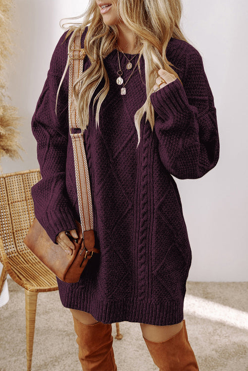A woman wearing a dark purple cable-knit sweater dress, styled with a brown leather crossbody bag 