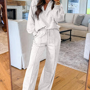 Person wearing a light gray outfit in a living room.