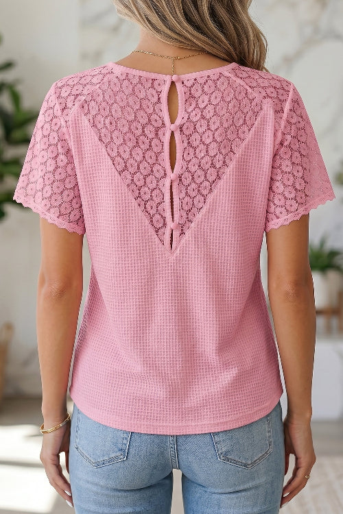 Pink lace top worn by a person with a blurred background