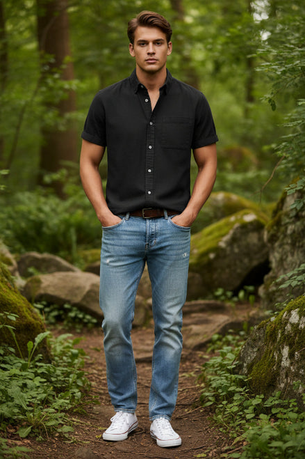 Person wearing a black short-sleeve button-up shirt with a plain background