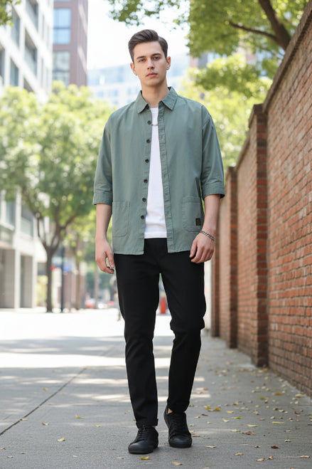 Person wearing a light green button-up shirt on a white background