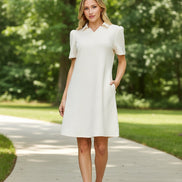Woman wearing a white dress against a beige background