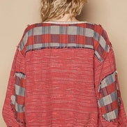 Person wearing a red plaid shirt and hat against a beige background