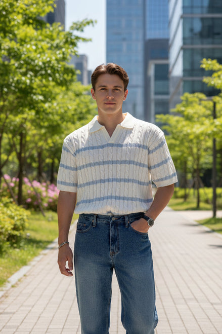 Person wearing a white and blue striped sweater with a blurred outdoor background
