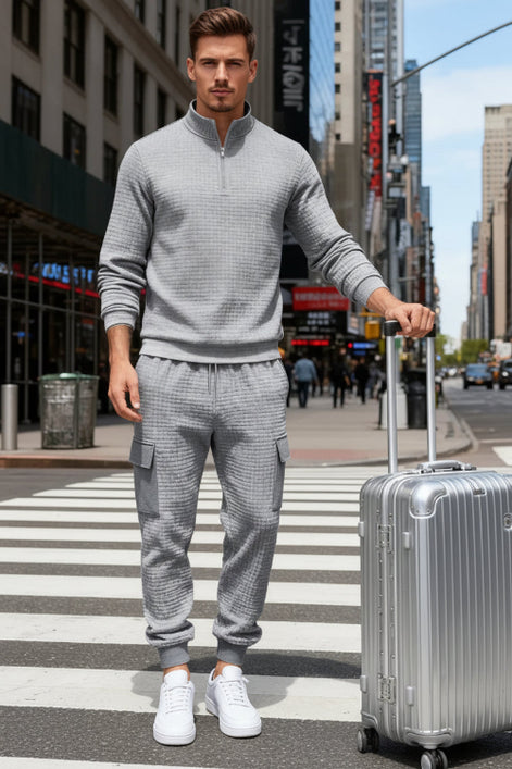 A man wearing a matching gray waffle-knit quarter-zip pullover and cargo jogger set 
