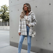 Person wearing a plaid jacket with a neutral background