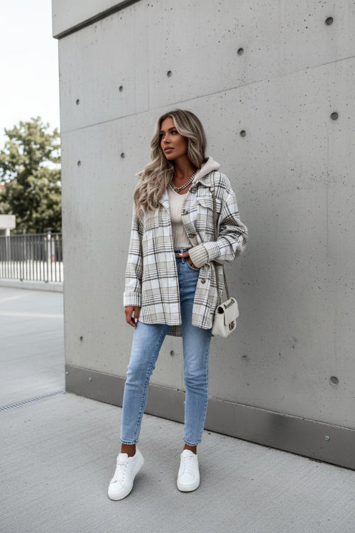 Person wearing a plaid jacket with a neutral background