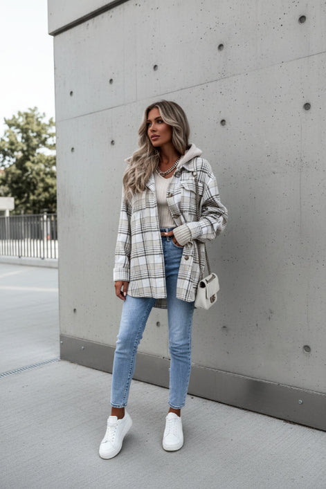 Person wearing a plaid jacket with a neutral background