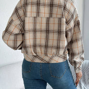 Person wearing a plaid shirt and blue jeans against a white background