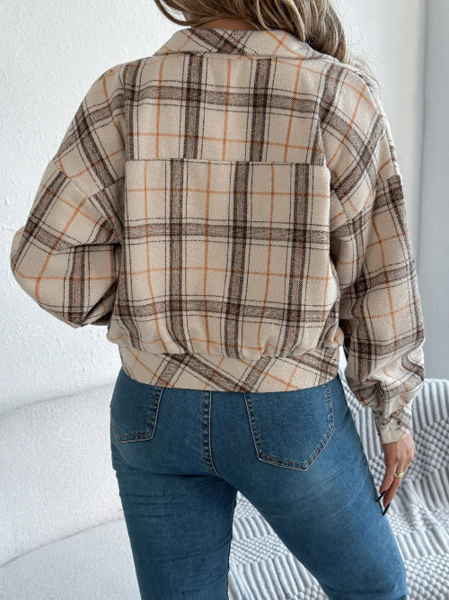 Person wearing a plaid shirt and blue jeans against a white background