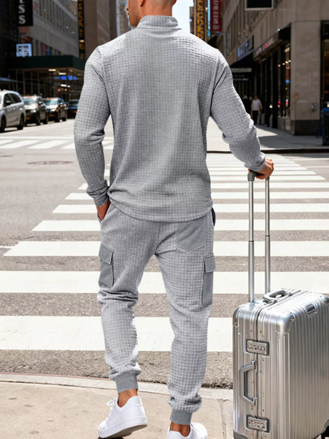 A man wearing a light gray waffle-knit matching lounge set, 