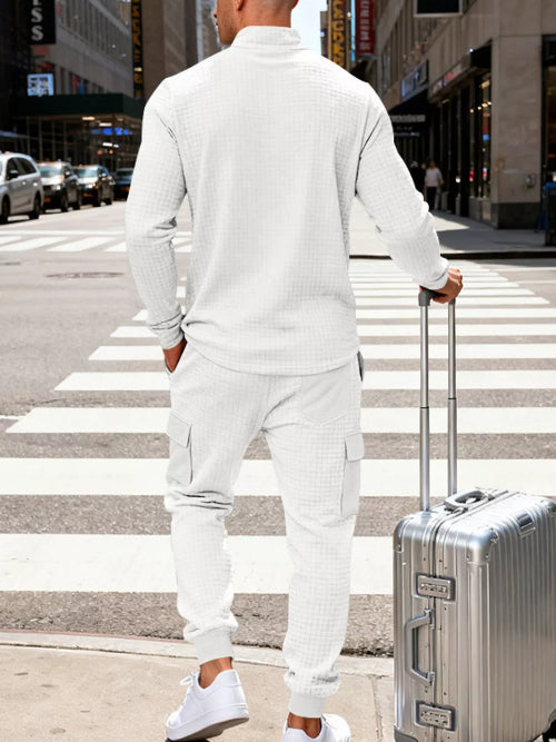 A man viewed from behind wearing a matching white textured long-sleeve top and jogger pants, 