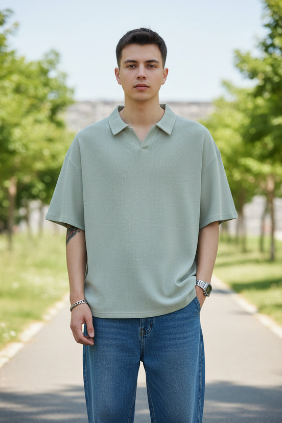 Person wearing a light gray polo shirt and blue jeans on a white background