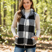 Person wearing a black and white checkered vest with a neutral background