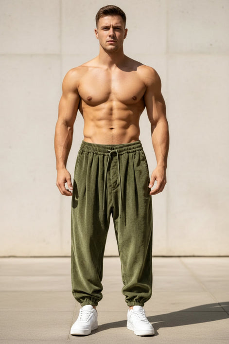 A man wearing loose olive green drawstring sweatpants and white sneakers, 