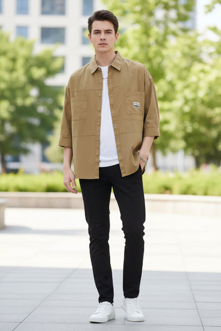 Man wearing a beige jacket with a brand logo on a white background